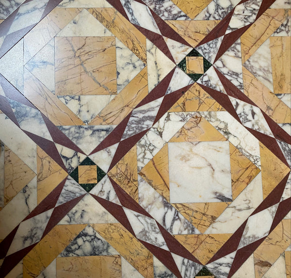 Marble floor with geometric pattern and a white dress with black shoes.
