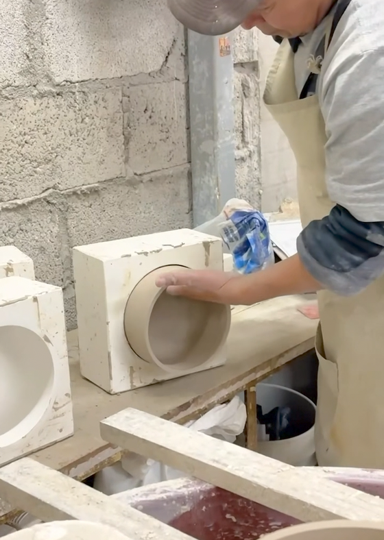 Person working with ceramic molds in a workshop setting